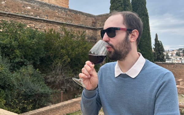 Juan drinking wine sat on the ramparts of a fort